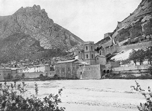 THE CHURCH TOWER STOOD OUT AGAINST THE ROCKY PEAKS