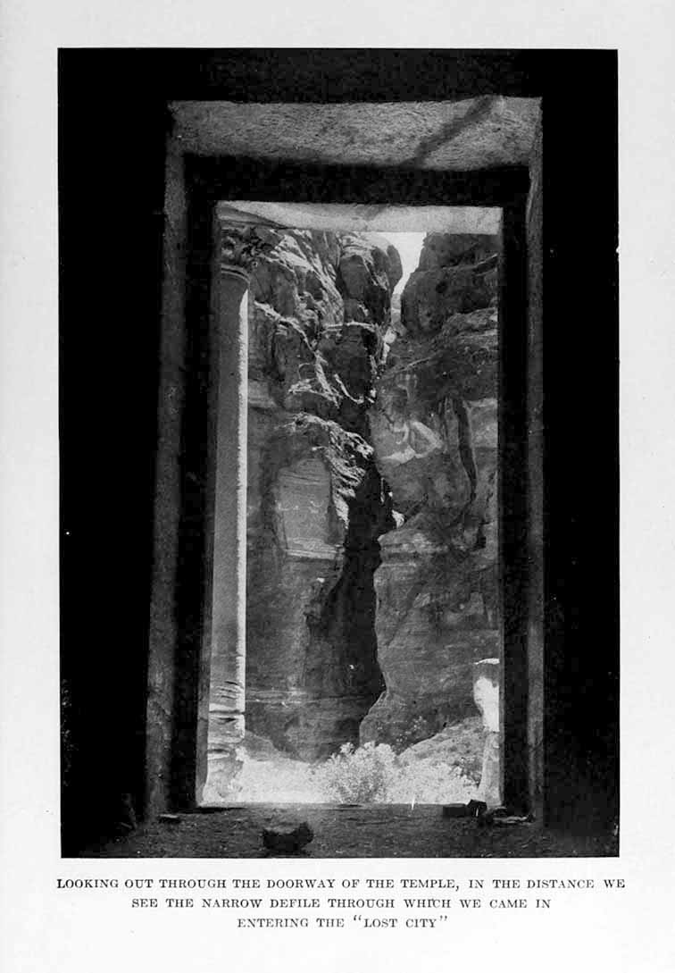 Photograph: LOOKING OUT THROUGH THE DOORWAY OF THE TEMPLE, IN THE DISTANCE WE SEE THE NARROW DEFILE THROUGH WHICH WE CAME IN ENTERING THE “LOST CITY”