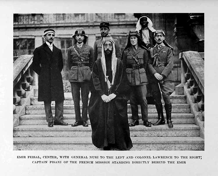 Photograph: EMIR FEISAL, CENTER, WITH GENERAL NURI TO THE LEFT AND COLONEL LAWRENCE TO THE RIGHT, CAPTAIN PISANI OF THE FRENCH MISSION STANDING DIRECTLY BEHIND THE EMIR