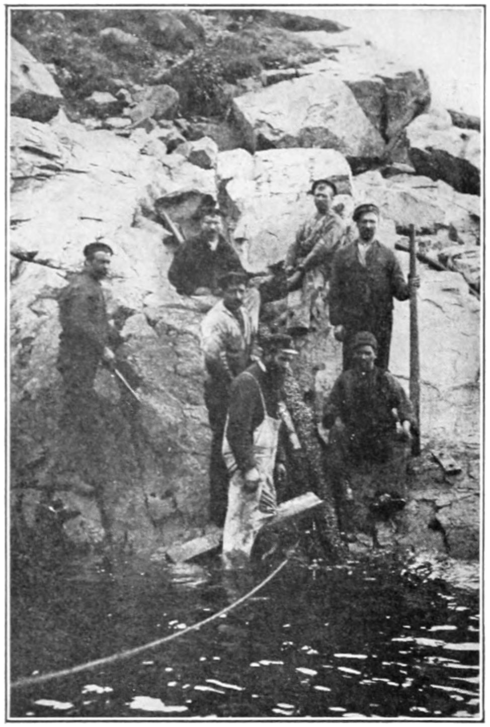 Cable repair crew on rocky sea shore
