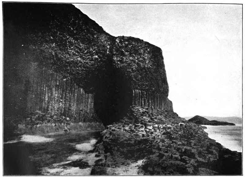 Steep rocky cliffs at the shoreline with large cave