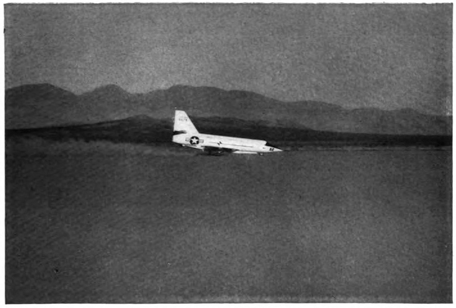 A plane landing with mountains in the background