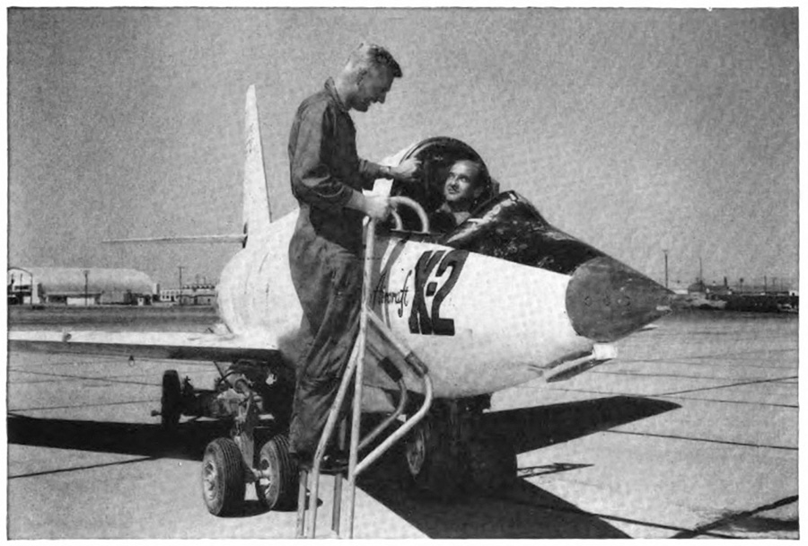 A man in a plane talking with a man on a ladder next to it