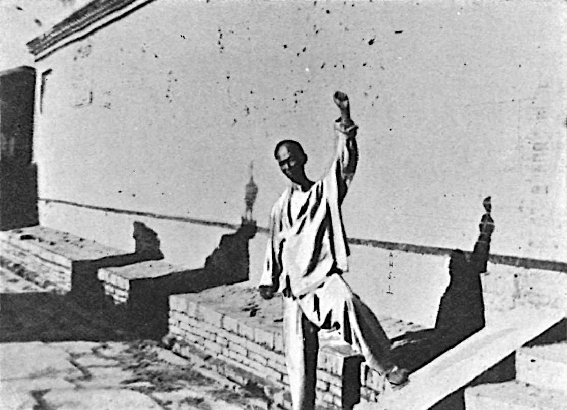 Photo of Boxer with fist raised, silhouetted against wall