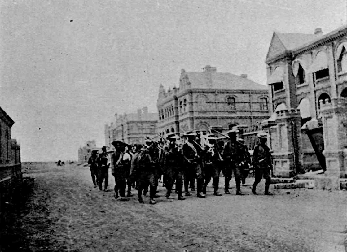 Men in center walking with many buildings behind and right