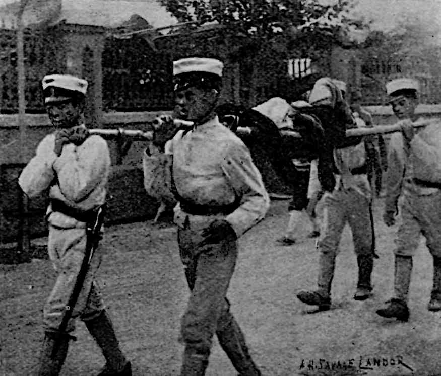 4 men in uniform carrying stretcher with person on it