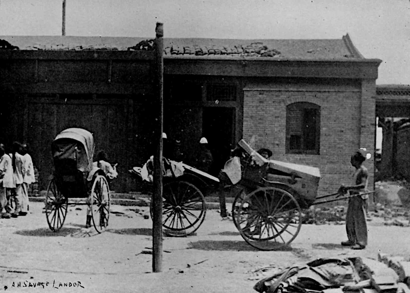 People moving loaded rickshaws in front of building