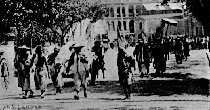 Several people in unique uniforms walking in front of a building