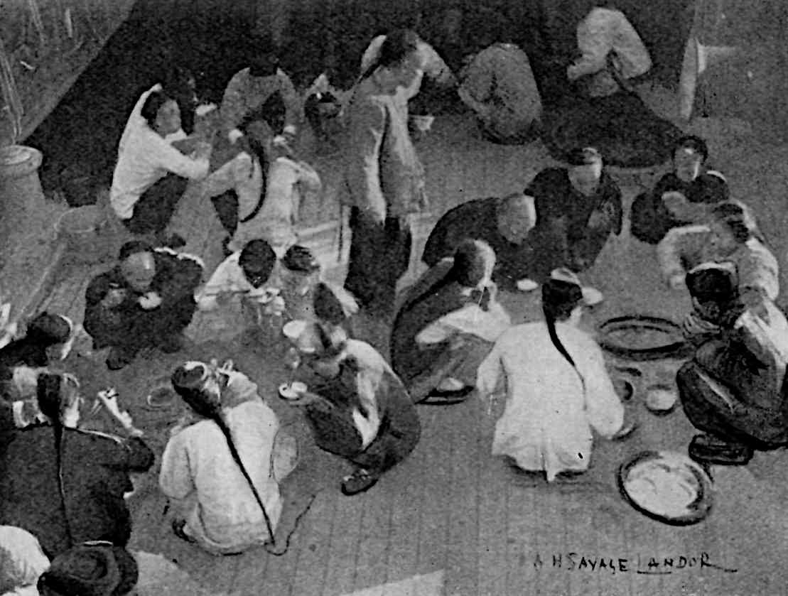 Many people eating while sitting on ground