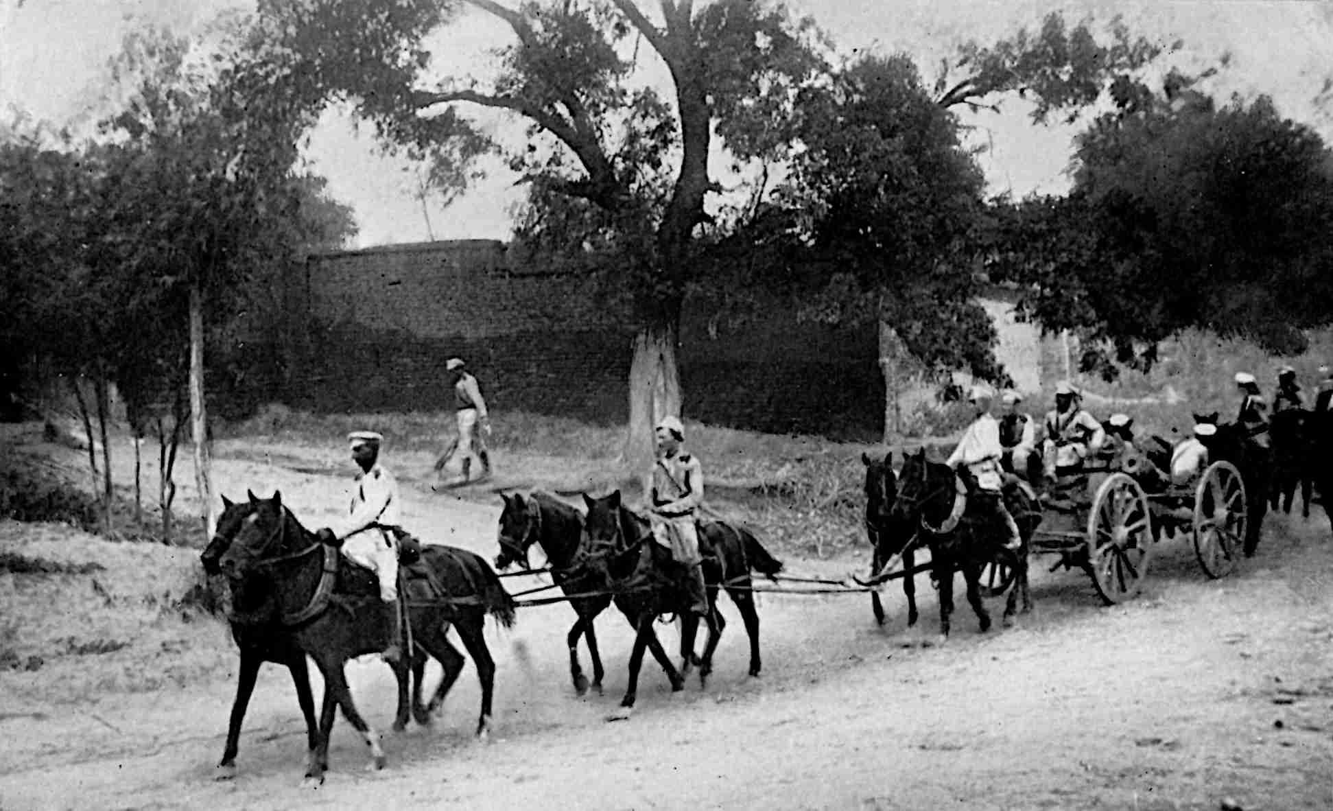 Several horses pulling artillery, with soldiers riding
