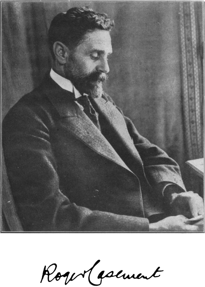 Foto von Sir Roger Casement,   lesend am Schreibtisch; unter dem Bild seine Unterschrift
